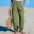 "YLR Essentials - High-waist loose beach pants, olive green, side view on beach"