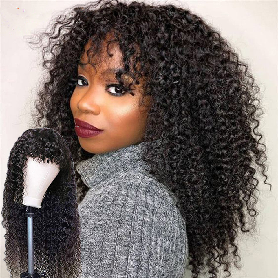 Model wearing long curly black wig with bangs, side view