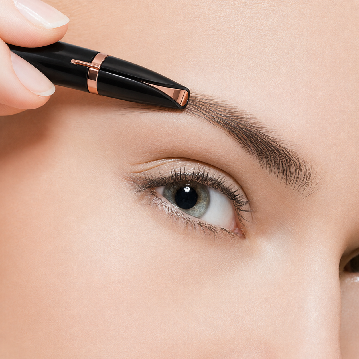 Close-up of a black electric eyebrow trimmer grooming an eyebrow